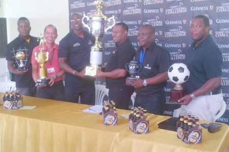Petra Co-Director Troy Mendonca (right) collects the championship trophy from Banks DIH Limited Guinness Brand Executive Lee Baptiste while other members of the launch committee look on.