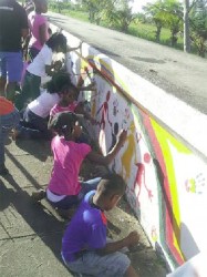 Children repainting a mural on the Kitty seawall on Saturday.
