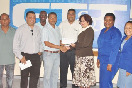 GCB Secretary Anand Sanasie (fourth from left) receives the sponsorship cheque from GT&T Director of Sales, Marketing and Public Relations Roma Narayan-Singh, while other representatives of the GCB and GT&T look on.
