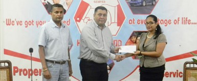  GCB Marketing Manager Raj Singh (second from left) receives the sponsorship trophy from Hand-in-Hand Marketing Coordinator Andrea Jodhan-Khan, as GCB Secretary Anand Sanasie looks on. 