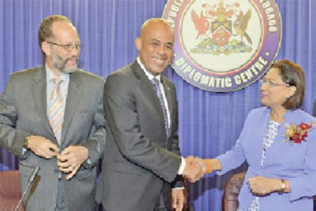 Caricom chairman Prime Minister Kamla Persad-Bissessar, right, greets Haitian President Michel Martelly during a special meeting of Caricom at the Diplomatic Centre, St Ann’s, Port of Spain, yesterday
