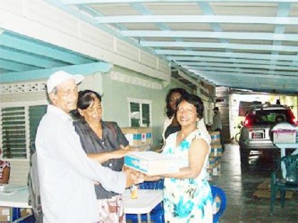 Member of Parliament Indranie Chandarpal handing over a laptop to one of the recipients at the One Laptop Per Family (OLPF) distribution exercise All Stars Sports Club, Supply, Mahaica. (Government Information Agency photo) 