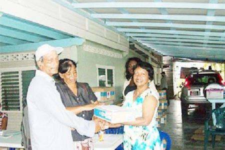 Member of Parliament Indranie Chandarpal handing over a laptop to one of the recipients at the One Laptop Per Family (OLPF) distribution exercise All Stars Sports Club, Supply, Mahaica. (Government Information Agency photo)
