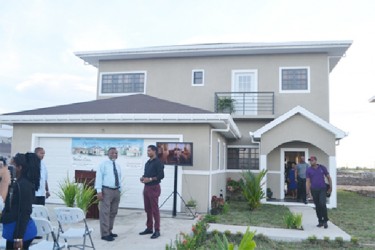 CEO Windsor Estates Danny Sawh and Prime Minister Samuel Hinds, standing in front of the company’s model home. (Government Information Agency photo)