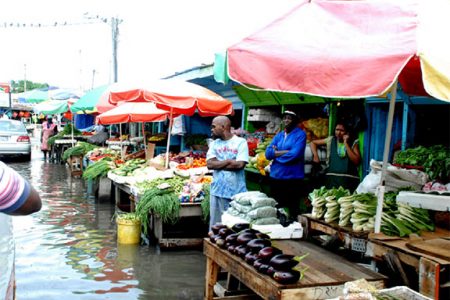 Making do: Vending above the flood at Bourda Market on Wednesday