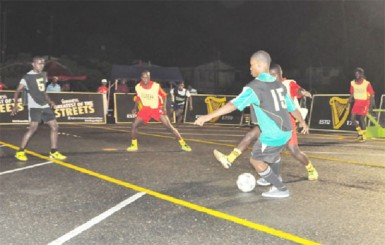 North East La Penitence’s Bevon Mosley (no.15) trying to keep possession of the ball against his Festival City marker in their group-C fixture 