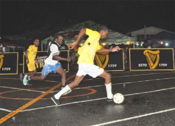 Christopher Darlington of California Square (right) in the process of attacking the Kingston goal with his (left) defensive marker in hot pursuit