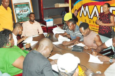 Boxers affixing their signatures to their respective contracts yesterday. (Orlando Charles photo) 