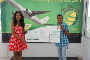 Fly Jamaica representative Susan Razack (right) presents a replica boarding pass to Go-Kart driver Emma Vieira, who won a round trip ticket to Jamaica. 