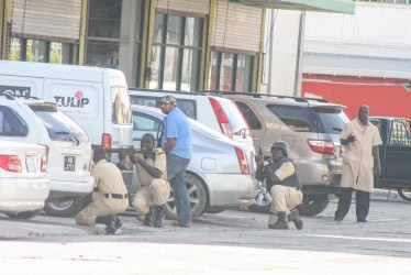 1)Policemen with an array of weapons during the confrontation with businessman Deryck Kanhai