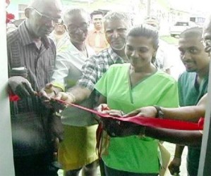 Dr. Renika Veerasammy being assisted to cut the ribbon the declare the  diabetic foot clinic open  