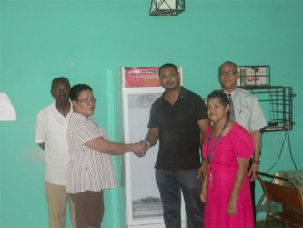 Norma Hamilton (second from left), Administrator of Uncle Eddie’s Home shakes hands with  Leader of Harmony Lodge Azad De Abreu during yesterday’s donation, while Gladwyn Anderson, VP of the Home’s Management Committee (at left), lodge member Neil D’Ornellas (in background at right) and a resident of the Home look on. 