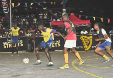 Andrew Murray Jr (second from left) of Albouystown-A in the process of receiving a pass while under pressure from a South Sophia player. (Orlando Charles photo) 