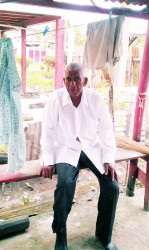 Latchman Balkram relaxing under his bottom house after a long morning in the field  