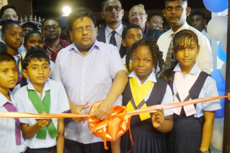 Dr. Ashni Singh cutting the ribbon to declare the bank open