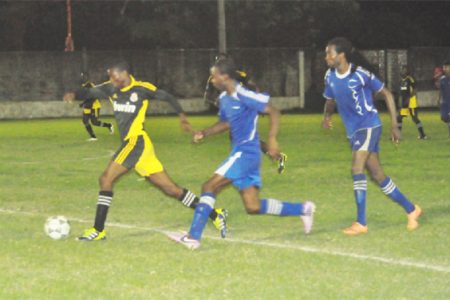BV Triumph United’s Akin Curry (centre) and Delroy Dean (right) in pursuit of a Grove Hi-Tech player.  (See story on page 27.)