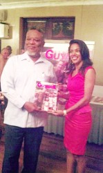 Prime Minister, Samuel Hinds (left) receives a copy of Explore Guyana 2014 from a member of THAG at the magazine’s launch.  