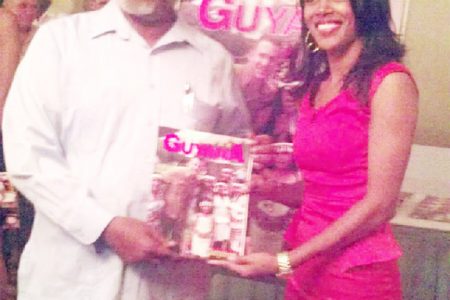 Prime Minister, Samuel Hinds (left) receives a copy of Explore Guyana 2014 from a member of THAG at the magazine’s launch.
