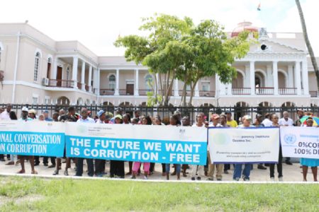 For a corruption-free future: The banners held up on Monday during the Transparency Institute Guyana Inc march which ended in front of Parliament.1