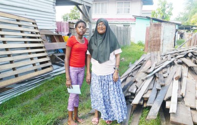 Farida Latiff and her daughter Rosanna stand near the materials from their dismantled home.  