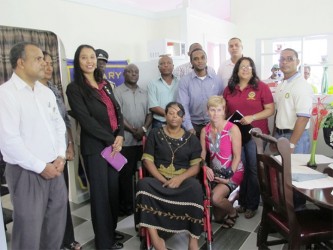 Former prison officer Roxanne Winfield with Stabroek Rotarians and representatives from some of the sponsor agencies at the handing over of her new newly-built disability-friendly home. The home was completely built by prisoners of the Lusignan Prison, according to the Rotary Club. (Rotary Club of Stabroek photo) 