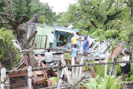 Salvaging what is useable after heavy winds blew down this house at Beterverwagting, East Coast Demerara yesterday (Photo by Arian Browne)