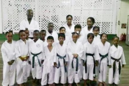 Sensei Winston Dunbar (left of standing row) posing with the successful students. Sadelle Britton is extreme right position in the front row.