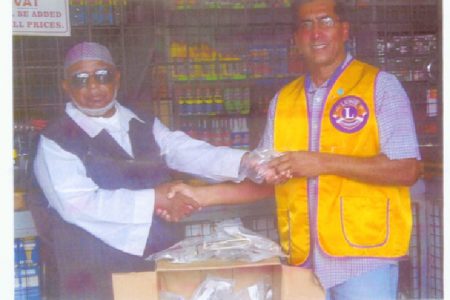 The Lions Club of Bel Air last Friday donated a number of tested reading glasses to two local Islamic organizations. In picture, President of the Lions Club of Bel Air Ray Seebarran hand over the glasses to Vibert Omar, former coordinator of the Central Islamic Organization of Guyana (CIOG) Albouystown Scout Group and  Public Relations Officer of Guyana Islamic Trust (GIT).  