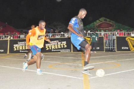 Hope Street Tiger Bay’s Rensford Coleridge (black vest/right) in the process of controlling the ball while Queen Street Tiger Bay’s Keoma Gravesande (yellow vest/left) attempting to dispossess him during their derby game. (Orlando Charles photo)