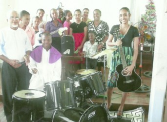  Members of the St Francis RC Youth Club try out the new drum set after the presentation while Father Joachim de Mello (standing left) looks on.  