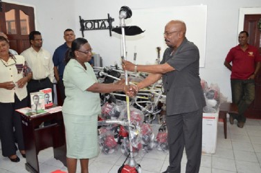 Minister within the Ministry of Local Government and Regional Development, Norman Whittaker (right) handing over a brush cutter to a representative of the Mackenzie Hospital, Region 10. (GINA photo)   