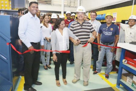 Internal Sales Representative Sonia Chan and MACORP CEO Jorge Medina cutting the ribbon to officially open the warehouse as Parts Manager Asif Sahid (left) looks on.

