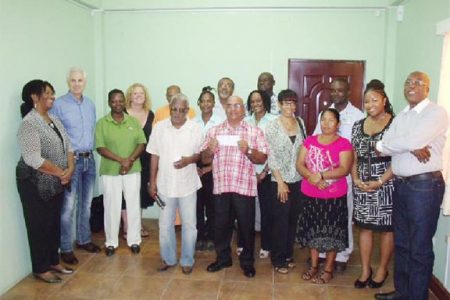 Guyana Goldfields staff pose with the recipients of the donations
