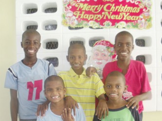 Excited for Christmas! (front to back, L to R) Anil, Alex, Stefan, Jamal and Addis, all of the St John Bosco Orphanage, pose for a photo after speaking with Stabroek News.