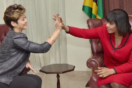 Prime Minister Portia Simpson Miller high-five’s Tessanne Chin
