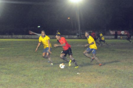 Alpha United Gregory Richardson on the attack with two Pele players in hot pursuit. (Orlando Charles photo)
