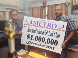 Representative of Metro Office and Computer Supplies, Ariff Baksh on behalf of the Kharag family handing over sponsorship cheque worth $1M which will go to the winning stable of the feature A and Lower event to Cecil Kennard.