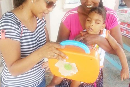 Shelly Bhagwandin demonstrating to Vishal’s grandmother how a toy works
