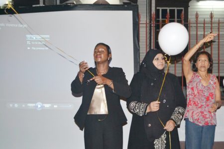Minister of Human Services and Social Security Jennifer Webster (left), Chairperson of the Rights of the Child Commission Aleema Nasir (centre) and First Lady Deolatchmee Ramotar letting go of balloons in front of Parliament building last night, symbolising the lives of women that were lost due to domestic violence. (GINA photo)