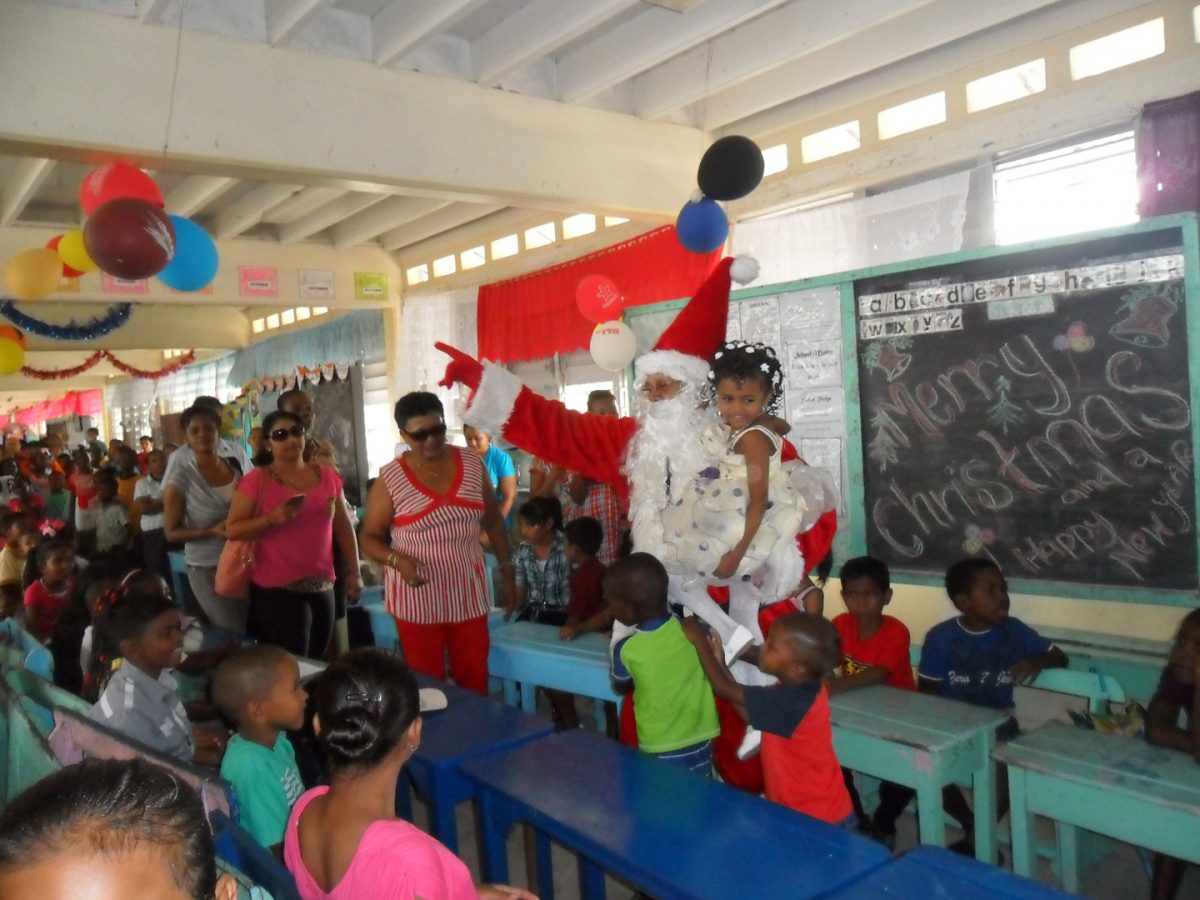 Yesterday,  First Lady Deolatchmee Ramotar’s  Foundation treated more than 240 children at a Christmas party held at the Charity Primary School, Region 2.  Photo shows Santa amid jollification. (Photo provided by First Lady’s office)
