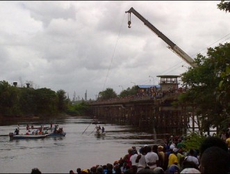 A crane lifts the vehicle from the Demerara River
