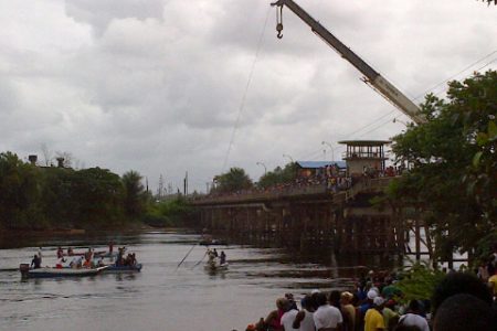 A crane lifts the vehicle from the Demerara River