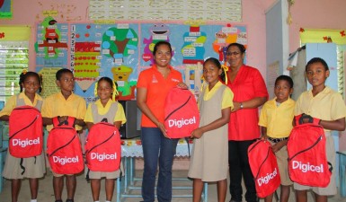 Vidya Bijall-Sanichara (Communications Manager) centre with students of Arakaka Primary School and Headmistress Bibi Samad. Digicel over the weekend handed over computers, backpacks and lunch kits to the pupils of the school. (Digicel photo)