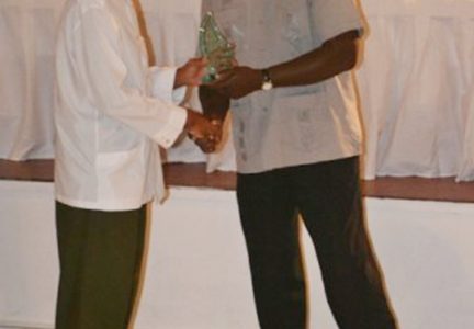 Former Guyana Airways pilot Peter Murray (left) receiving his long service award from Minister of Transport Robeson Benn. (GINA photo)