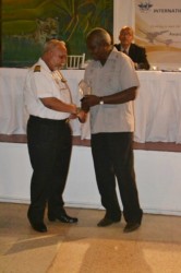 Former Guyana Airways pilot Azeez Nazamudeen (left) receiving his long service award from Minister of Transport Robeson Benn. (GINA photo)