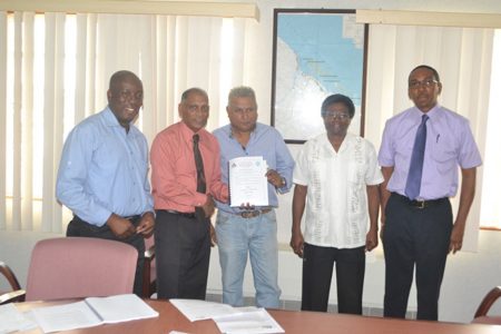 Minister of Agriculture Dr. Leslie Ramsammy (second from left) hands over the contracts for the design and supervision of the Parika-Ruby, Laluni and Onverwagt roads to the contractor from SRK Engineering. The Caribbean Development Fund has approved US$8M in contracts for the rehabilitation of the three roads.  (GINA photo)