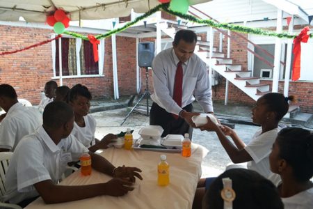 Minister of Culture, Youth and Sport, Dr. Frank Anthony serving students at the Sophia Training Centre at their first Christmas Luncheon on Wednesday. The luncheon was held at the centre’s lawns, Dennis Street, Sophia. (GINA photo)
