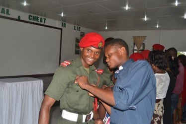 The Guyana Defence Force (GDF) yesterday hosted its Ensigncy Parade at the Drill Square, Camp Stephenson, Timehri where 15 officer cadets who completed the Standard Officers’ Course # 46 were promoted to Ensigns. In this GINA photo ensign Simon Gordon receives his new tag from a family member.