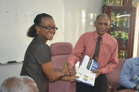 Food and Agriculture Organisation (FAO) Representative in Guyana Dr. Lystra Fletcher-Paul (left) presenting Minister of Agriculture Dr. Leslie Ramsammy on Wednesday with a copy of the UN Water County Brief produced on Guyana. (GINA photo)
