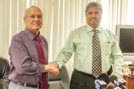 Former DDL chairman Yesu Persaud (left) shakes the hand of the man appointed to take the company into the future, Komal Samaroo